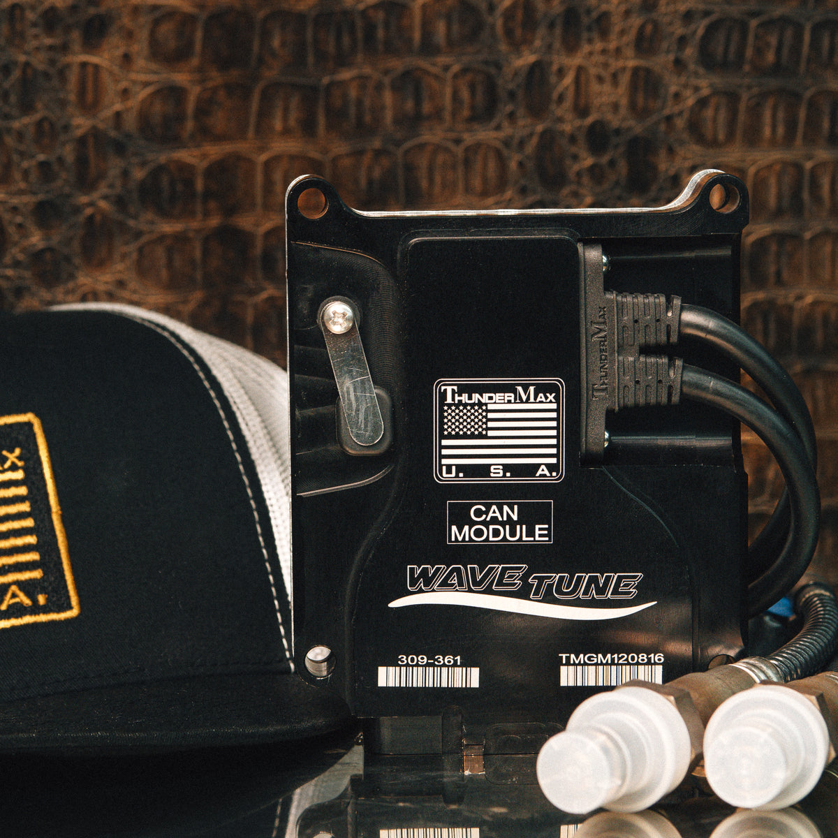 ThunderMax 309-466 ECM and wideband oxygen sensors beside a ThunderMax cap