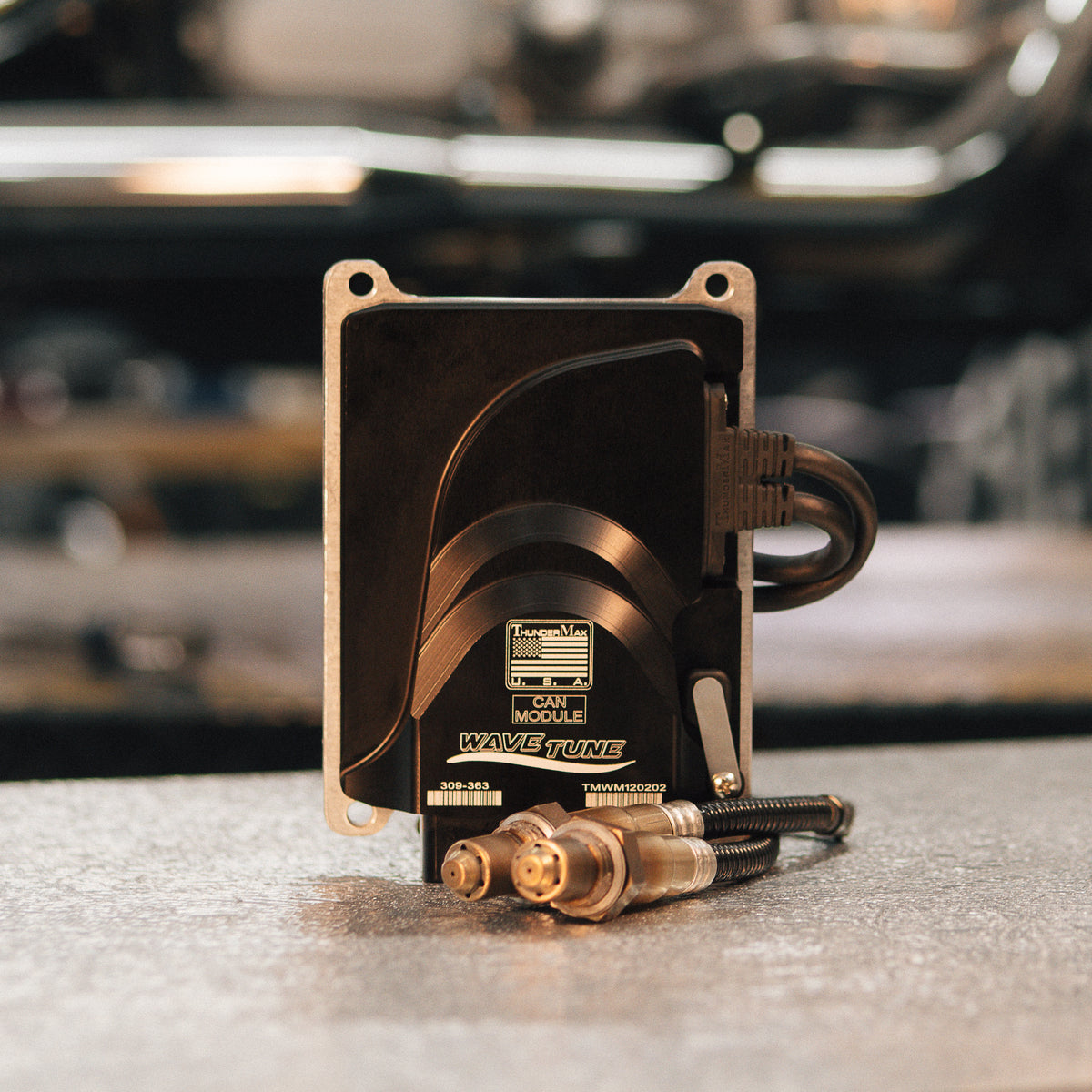 ThunderMax 309-363 ECM and wideband oxygen sensors displayed on a gray workbench