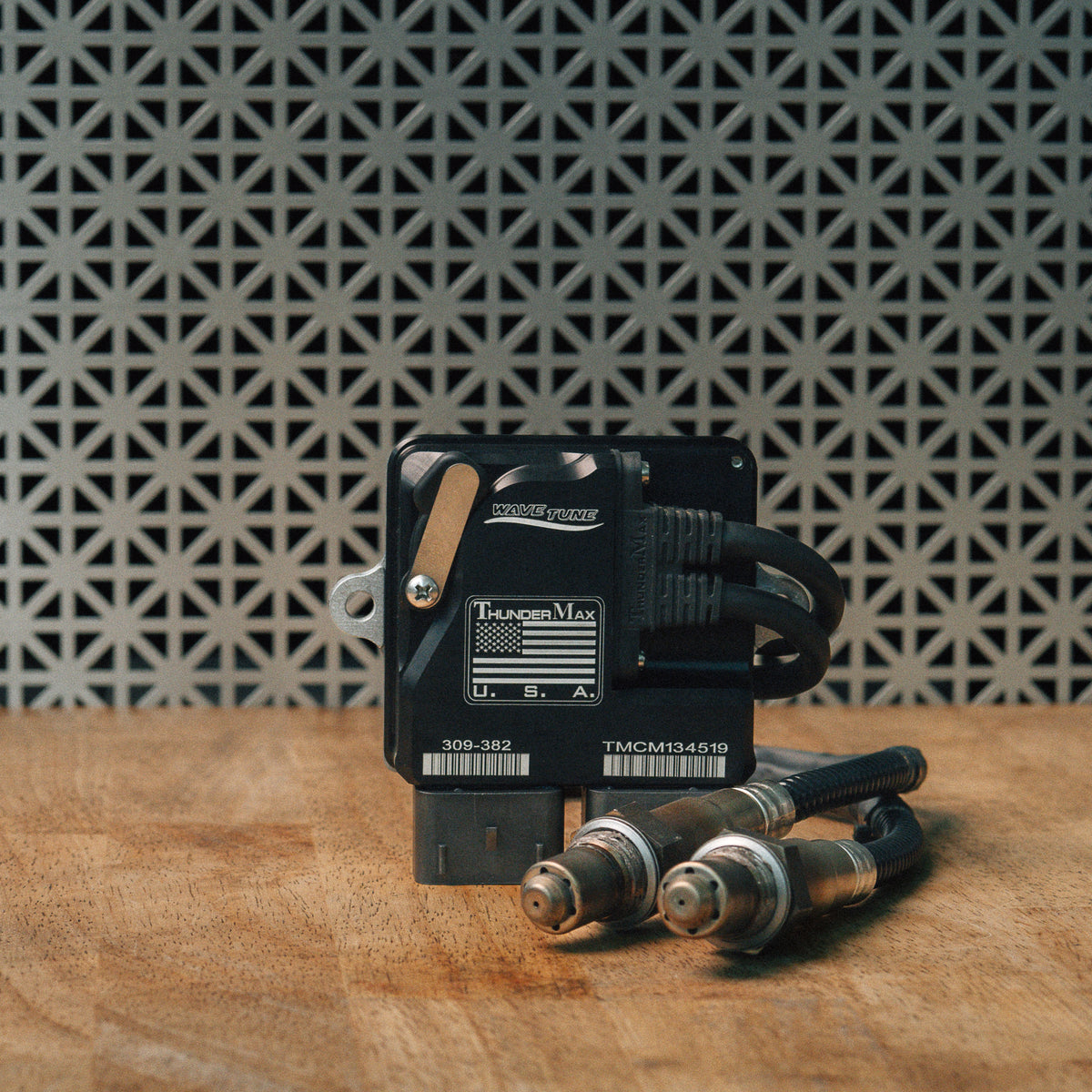 ThunderMax 309-382 ECM and wideband oxygen sensors displayed on a wooden workbench