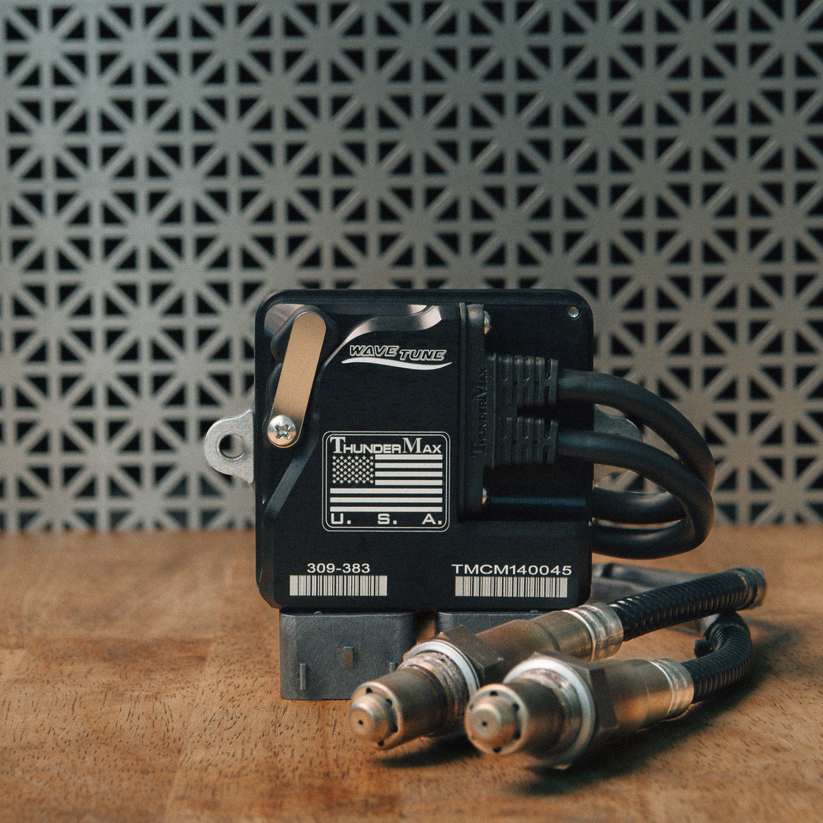 ThunderMax 309-383 ECM and wideband oxygen sensors displayed on a wooden workbench