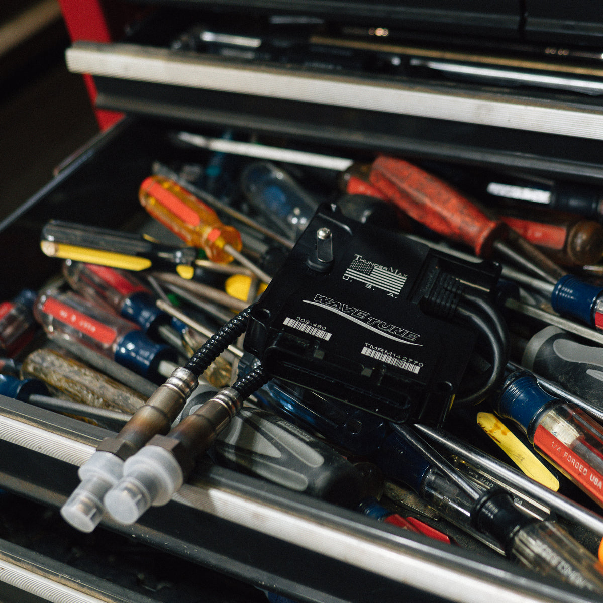 ThunderMax 309-460 ECM and wideband oxygen sensors displayed in a tool drawer