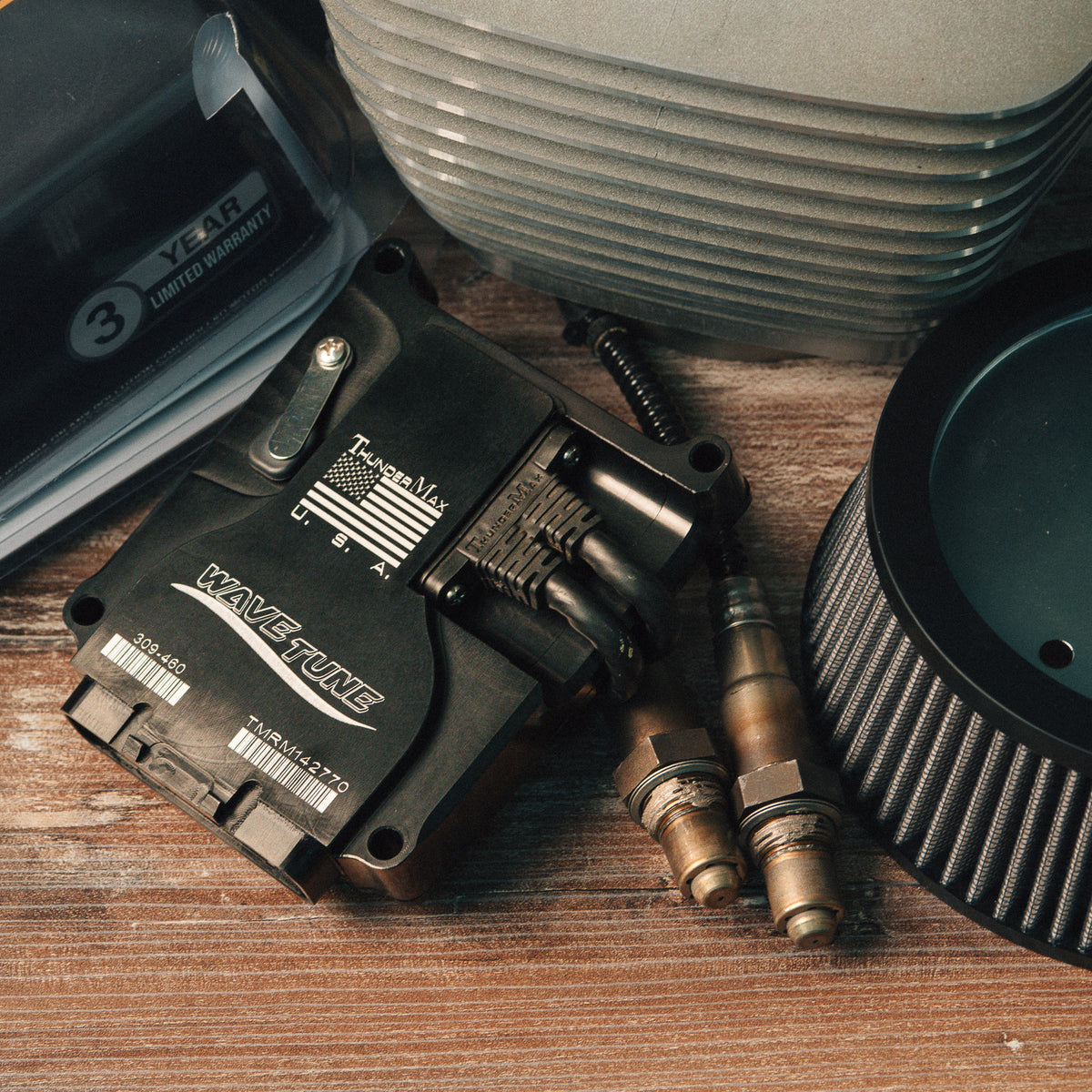 ThunderMax ECM and wideband oxygen sensors beside engine cylinders and an air filter