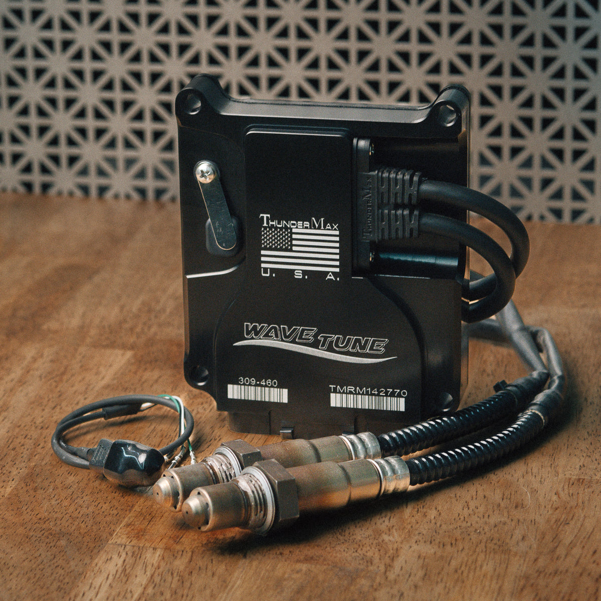ThunderMax 309-485 ECM and wideband oxygen sensors displayed on a wooden workbench