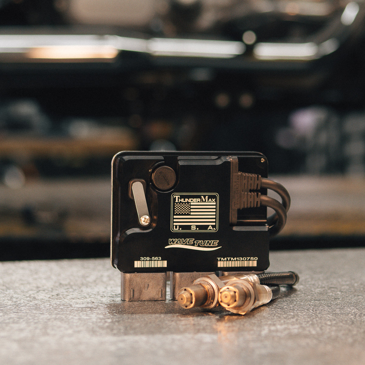 ThunderMax 309-563 ECM and wideband oxygen sensors displayed on a gray workbench