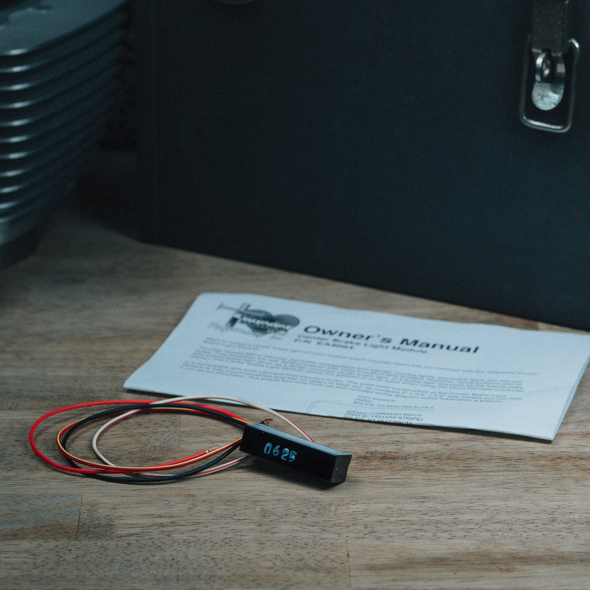 EA4094 center brake light module, wiring and instruction sheet on a workbench