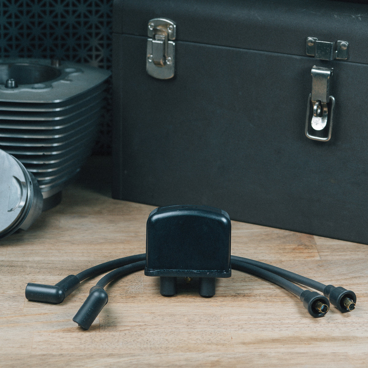 Ignition coil with two plug wires attached on a wooden workbench