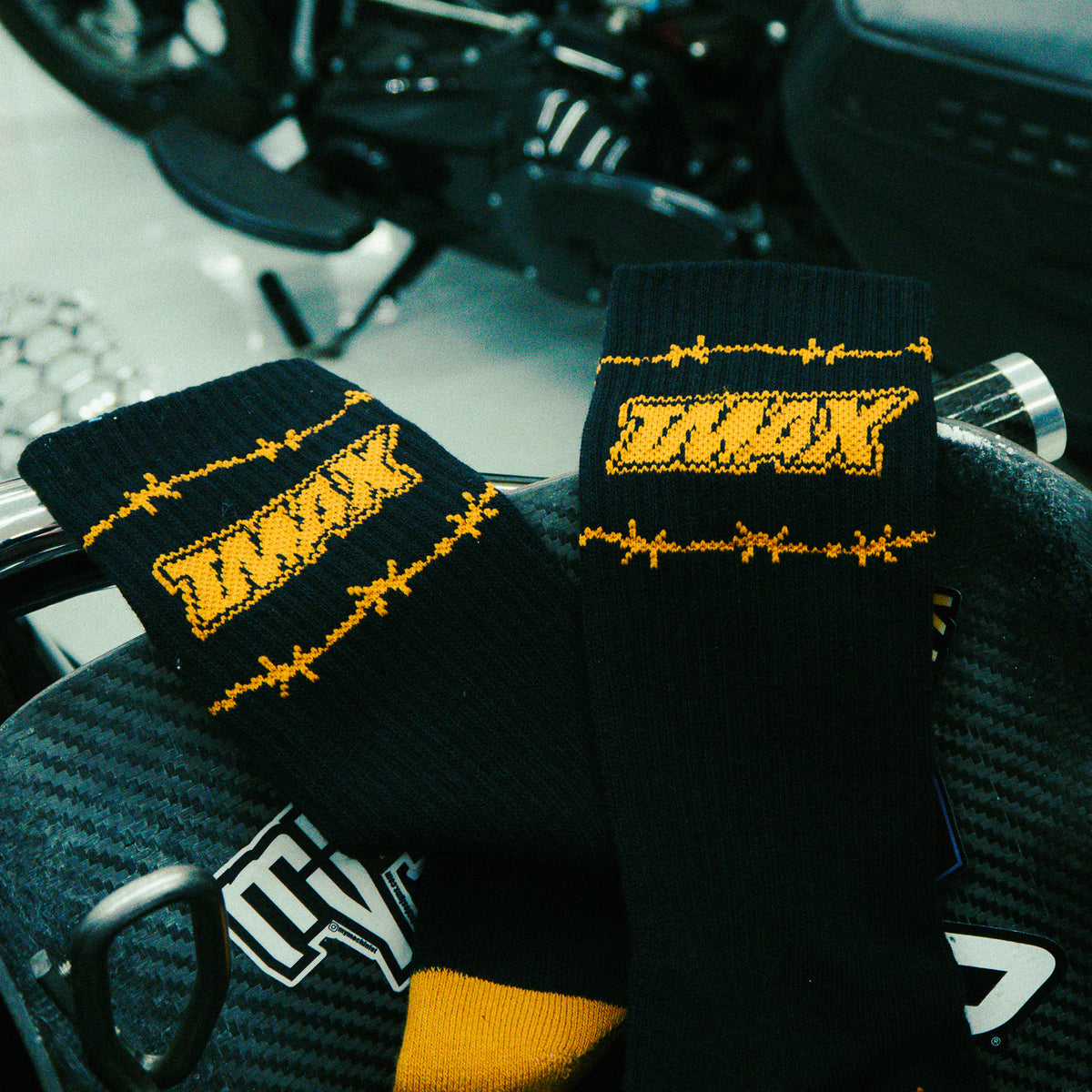 Flames Forever socks showing gold TMAX lettering and barbed-wire graphics