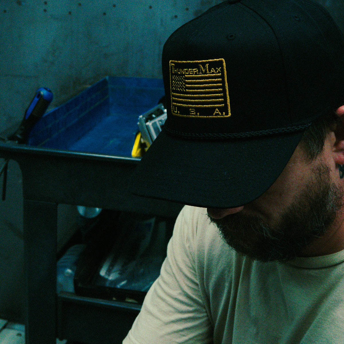 Person wearing a TMax Flag Rope hat, showing the gold ThunderMax flag patch